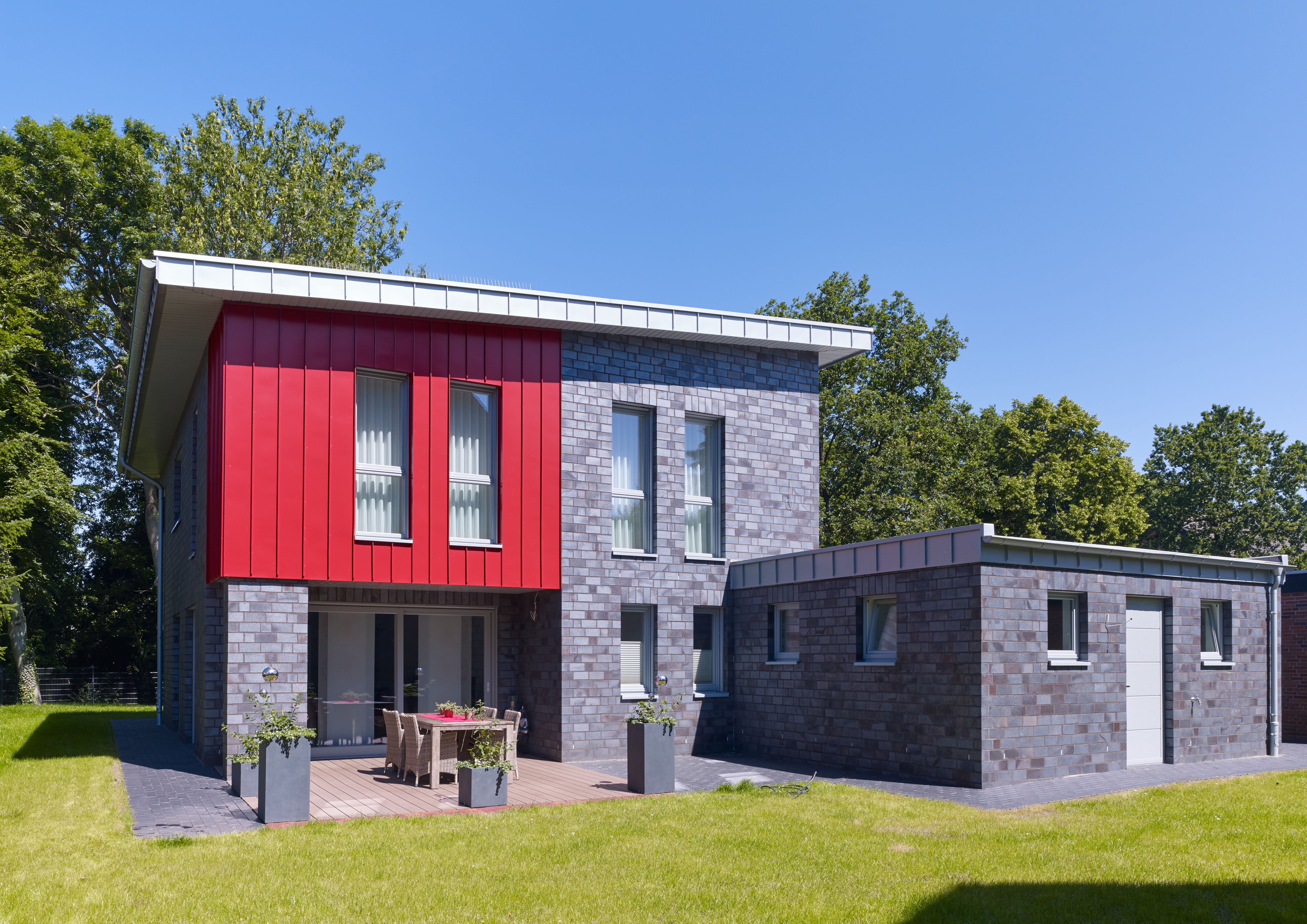 Wohnhaus mit Zink in Rot und Dachrand in Blaugrau